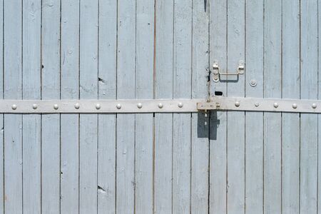 Old painted wooden garage door of grey color