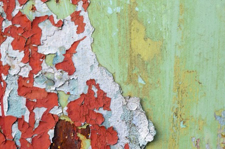 Green and red flaking paint on on old metal surface. Old metal texture for background