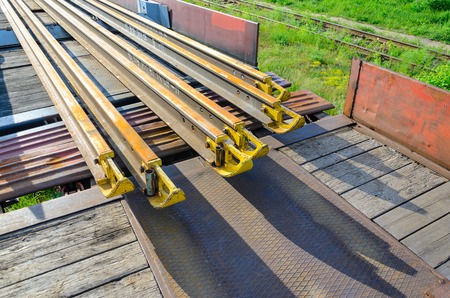 Railhead elements. Transportation of long new rails on a freight car. Endless path. The rail lash. Special load.の写真素材