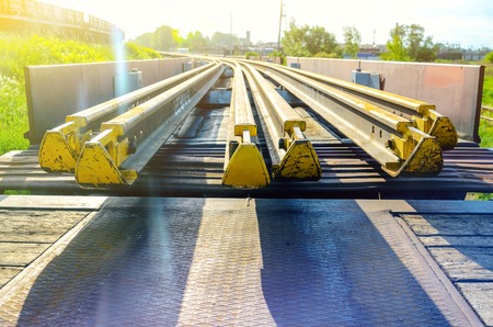 Railhead elements. Transportation of long new rails on a freight car. Endless path. The rail lash. Special load.の写真素材