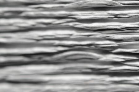 White texture of embossed paper. Macro. Shallow depth of field. Abstract background with deep grooves in the texture of corrugated paper. Pattern of horizontal groovesの写真素材