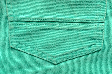 Green Denim Tissue Structure Textile Texture Close-up. Macro shot of the finishing seam on a green jeans product.の写真素材