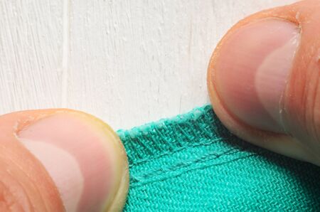 Inner seam on clothes pressed close to the table with hands. Close-up shot of a tailor at workの写真素材