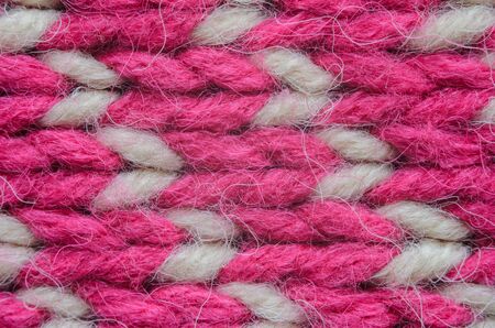 Texture of a beige and red knitted sweater close-up. Abstract pattern on winter knitted clothes