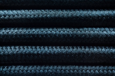 Wires in Black Textile Braid Background. Texture of Black Cablesの写真素材