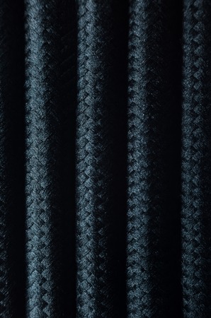 Wires in Black Textile Braid Background. Texture of Black Cablesの写真素材