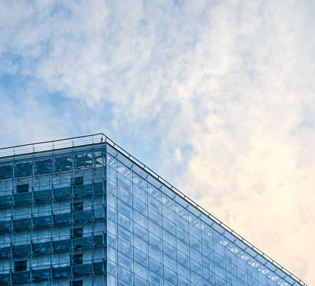 Glass facade of tall office building on blue skyの写真素材