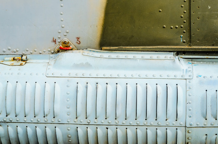Old aircraft fuselage close up. Door handle and rivets.