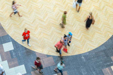 Silhouettes of Walking People in the Atrium of a Large Public Building, View from Above. Blur in...