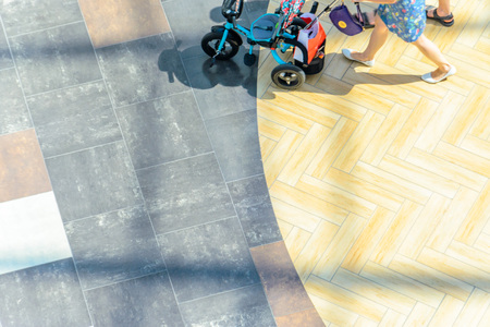Woman with a baby stroller, top view. Blur in motion, abstract background with blank space for text...