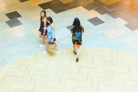 Silhouettes of Walking People in the Atrium of a Large Public Building, View from Above. Blur in...