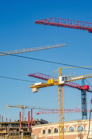 Crane and building construction site against blue skyの写真素材