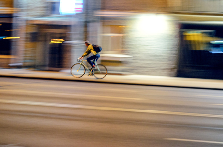 Motion Blur. Abstract Blur Picture of Male Cycling on Fixed Gear Bicycle in Night Cityscape, Speed Conceptの写真素材
