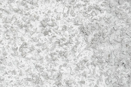 Rough Concrete Wall Decoration, Painted White. White Concrete Wall with Many Protruding Stones.