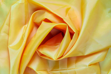Yellow Synthetic Lining Fabric with Folds. Crumpled Sheet or Clothes Background,の写真素材