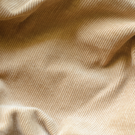 Texture of Soft Velvet Fabric with Folds Closeup. Texture of Beige Velvet Clothes. Textile Fabric of Corduroy as Backgroundの写真素材