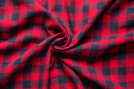 Wrinkled plaid material. Red dark blue checkered shirt cloth background. Twisted in the center cloth swatchの写真素材
