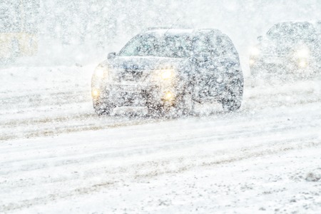 Car rides through a snowstorm. Limited vision on the road. Blizzard - car traffic in bad weather conditionsの写真素材