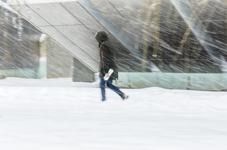 Silhouette of a late man. Hurry up in bad weather. Winter weather concept. Abstract blurred in motion backgroundの写真素材