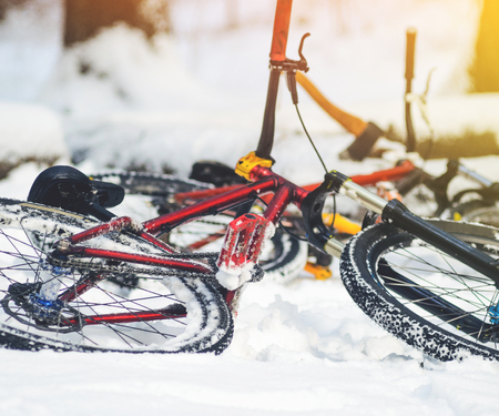 Two bike for extreme riding lie in the snow-covered forest. Winter mountain biking backgroundの写真素材