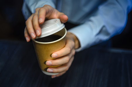 Barista serves coffee to the client. Hands Paper cup Bar counter Cappuccino Plastic cap. Coffee Business Conceptの写真素材