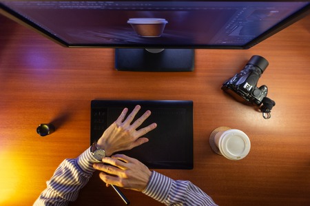 Desktop top view. Computer Graphics Tablet Camera Cup of coffee Hand Flat lay. Concept for website banner, mockup, background, presentation and marketing materialの写真素材