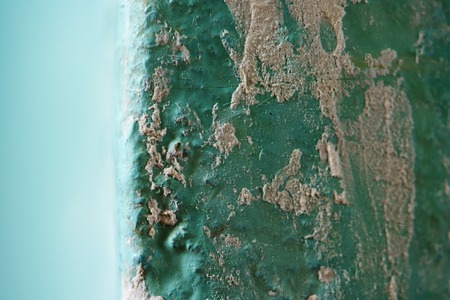 Peeling Blue Aquamarine Color Paint from Outer Corner of the Wall. Shattered Plaster Background. Abstract Blurry Backdropの写真素材
