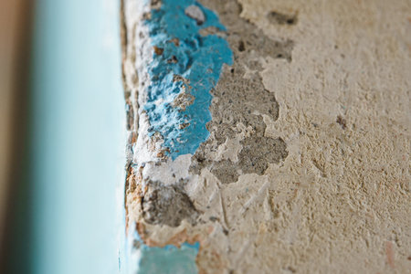 Peeling Blue Aquamarine Color Paint from Outer Corner of the Wall. Shattered Plaster Background. Abstract Blurry Backdropの写真素材