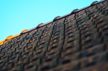 Old Red Ceramic Roof Tiles Background. Old Pitched Roof. Roof Ridge