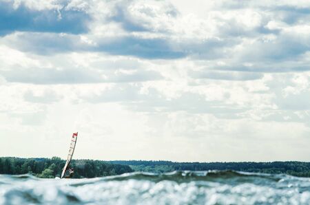 Windsurfer catches the wind and cuts the waves while driving fastの写真素材
