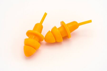 Orange earplugs on white background. Protection noise. Safety. Copy space