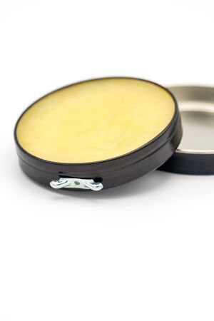 Colorless transparent wax for shoes. Open round container on a white background Shoe care conceptの写真素材
