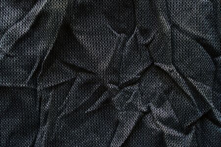 Crumpled black fabric texture. Clothing materials backgroundの写真素材