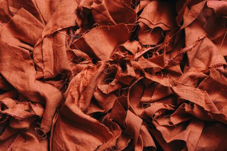 A pile of scraps of red linen fabric. Fabric background. Make clothesの写真素材