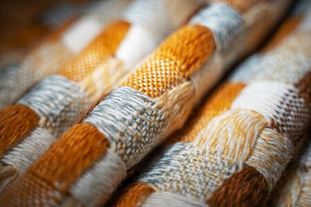 Stacked Knitted Plaid Background. Knitwear Blanket Fabric Texture with a Complex Square Interweaving.の写真素材