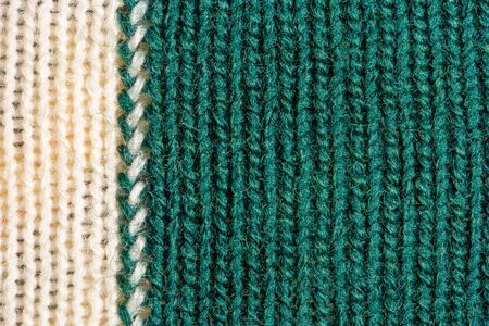 Green and white knitting wool texture. Cloth background close up