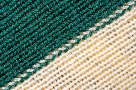 Green and white knitting wool texture. Cloth background close up