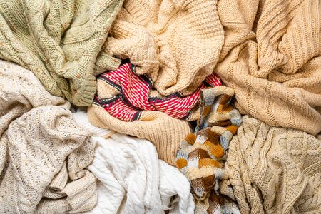 Many Knitted Winter Sweaters Piled in a Heap. Abstract Background of Winter Clothingの写真素材