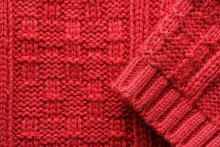 The texture of a knitted sweater. Red pattern. Facial surface. Background. Copy space