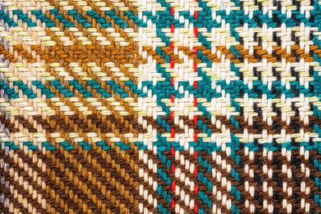 Brown checkered fabric with colored threads. Scottish wool. Fabric for plaid coat and suit. Close-up. Backgroundの写真素材