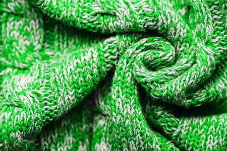 Knitted Sweater Background Twisted into a Spiral. Green white mottled pattern. Facial surface. Copy spaceの写真素材