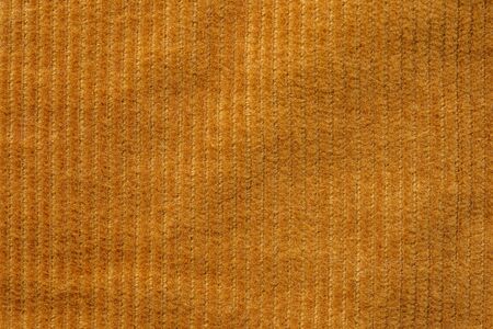 Texture of corduroy velvet fabric close-up. Texture of rufous velvet clothes. Textile fabric as backgroundの写真素材