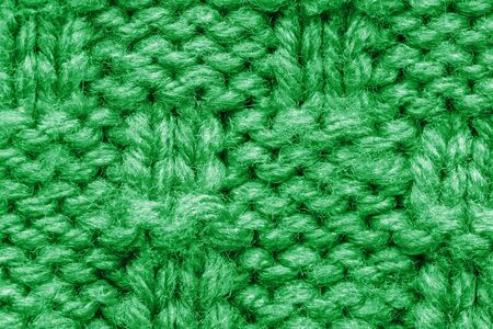 The texture of a knitted sweater. Green pattern. Facial surface. Background. Copy spaceの写真素材