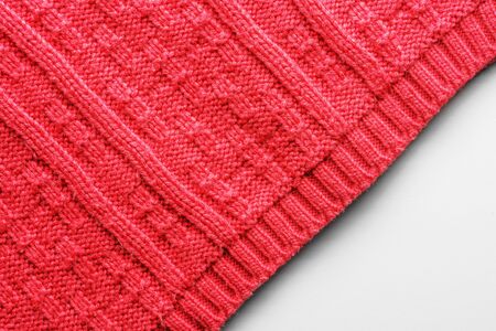 The texture of a knitted sweater. Red pattern. Facial surface. Background. Copy space