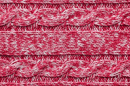 The texture of a knitted red white sweater. Beautiful textured arana patterns. Background. Copy...