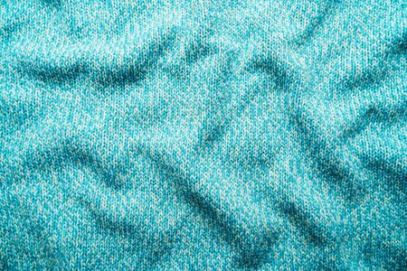 Crumpled texture of a blue turquoise knitted fabric. Sweater backgroundの写真素材