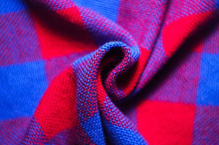 Plaid material. Red and blue cage clothes. Crumpled twisted fabric background