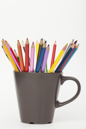 colored pencils in mug on white backgroundの写真素材