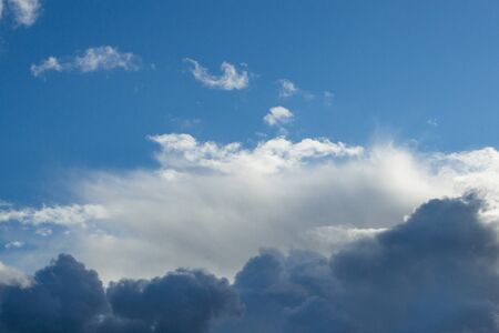 Evening clouds on the background of the blue sky.