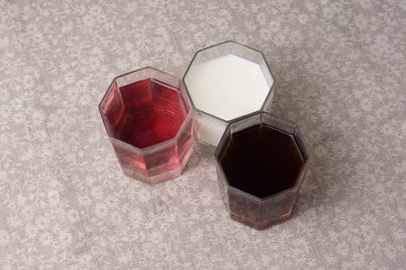 Various drinks in three glasses on the background of a linen tablecloth